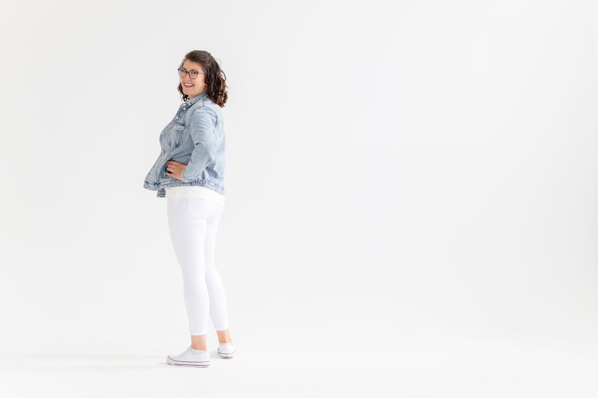 Evi Hollmann in Jeansjacke schaut lächelnd über die Schulter