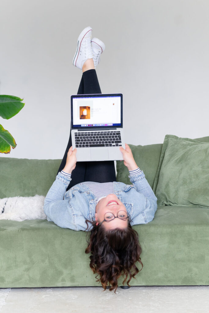 Evi liegt kopfüber auf dem Sofa und lacht