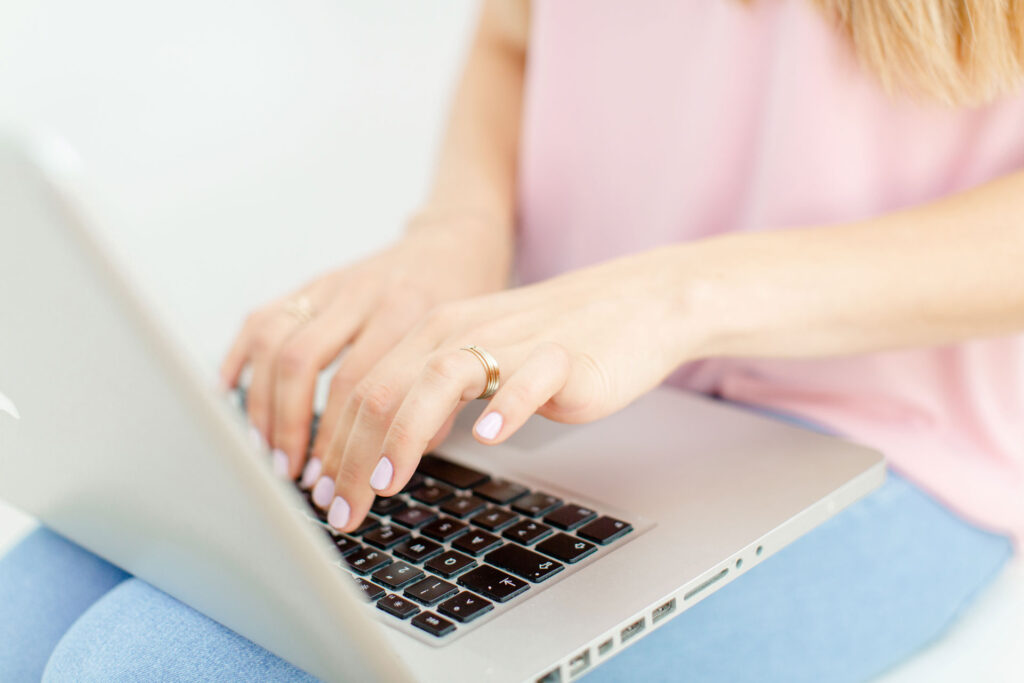Hände einer Frau am Laptop arbeitend